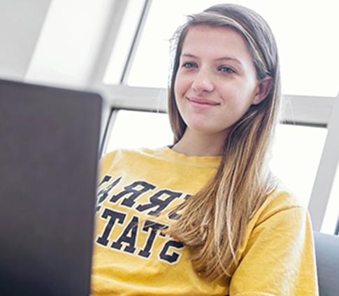一个女孩在地区校园用笔记本电脑工作